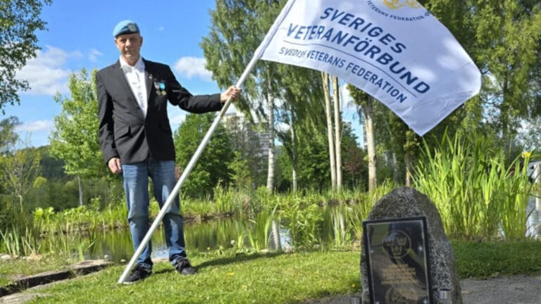 En man står och håller i en fana.