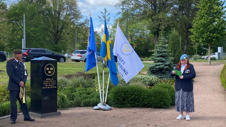 En kvinna håller tal utomhus.