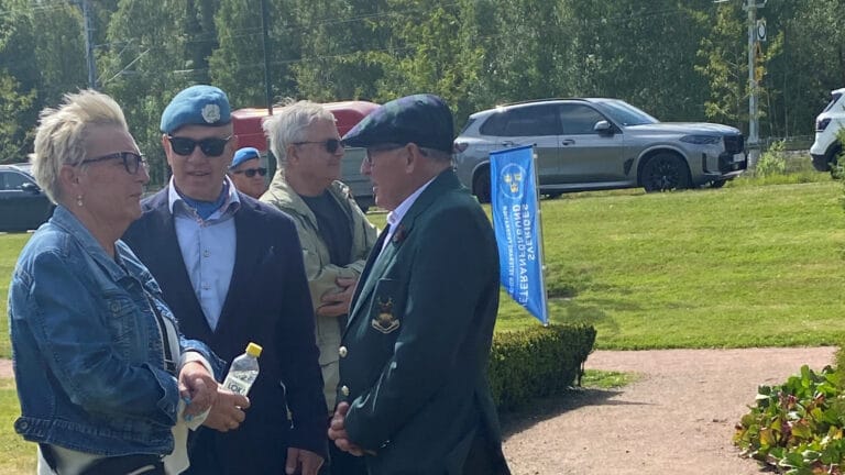 Två män och en kvinna talar med varandra.